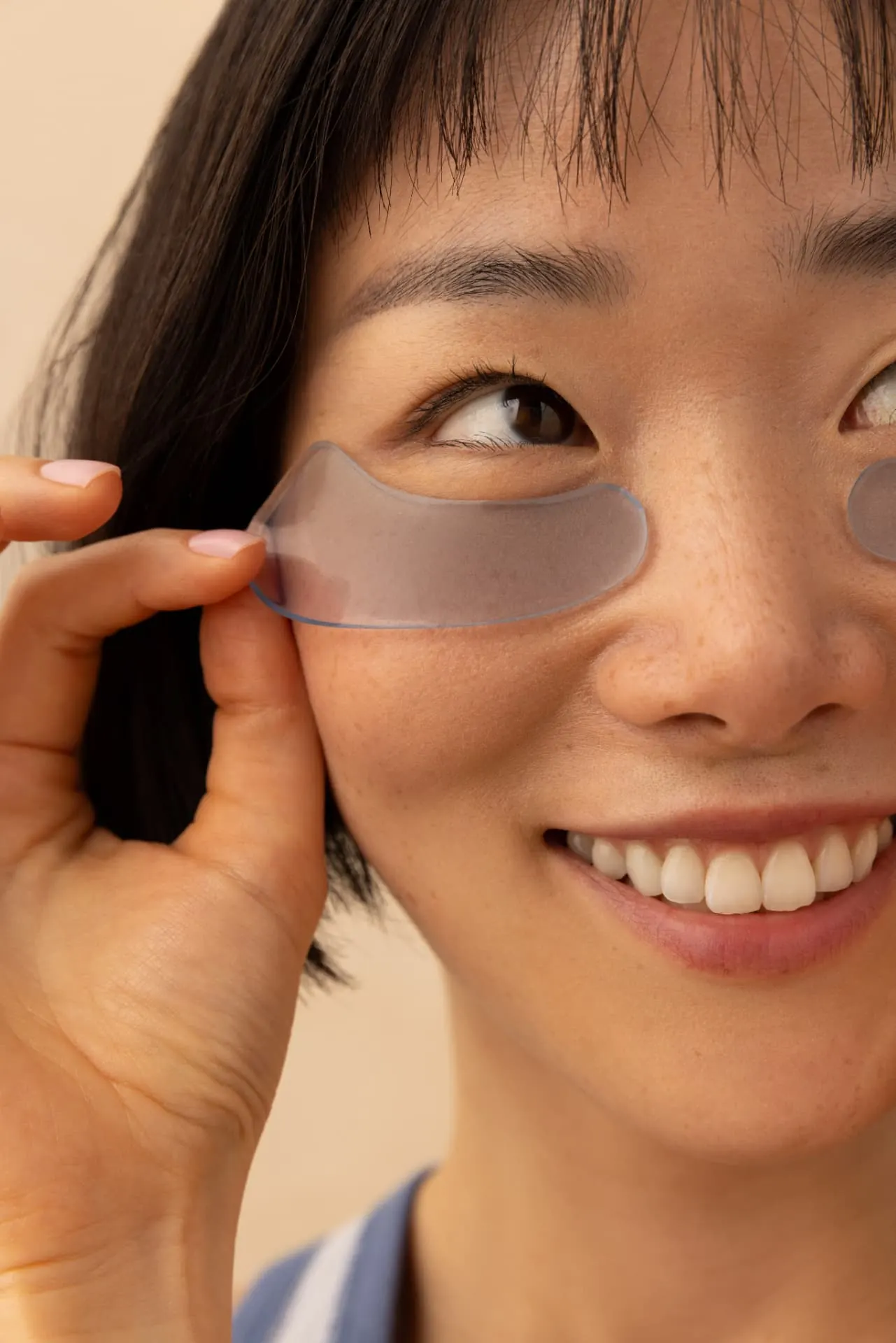 Applying a De-Puff undereye patch under the eye